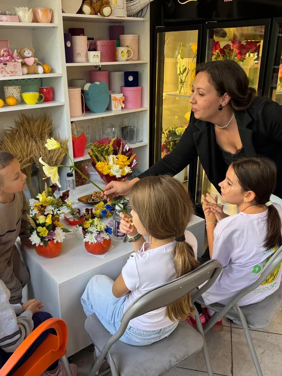 Atelier de florărie la Atena Afterschool Craiova: copii aranjând flori, îndrumați de educator